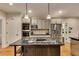 Bright kitchen featuring a central island with cooktop, stainless steel appliances, and custom cabinetry at 3028 Towneside Ln, Woodstock, GA 30189