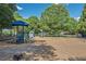 Community playground with a variety of colorful play equipment for , surrounded by trees at 3028 Towneside Ln, Woodstock, GA 30189