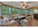 Relaxing screened porch with wicker seating, ceiling fan, wooden flooring, and a view of the serene woods at 3028 Towneside Ln, Woodstock, GA 30189