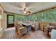 Covered porch featuring wicker furniture, ceiling fan, wooden flooring, and a view of the peaceful wooded area at 3028 Towneside Ln, Woodstock, GA 30189