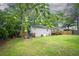 Spacious backyard features a well-maintained lawn, mature trees, and wooden deck at 4409 Woodward Mill Rd, Sugar Hill, GA 30518