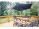 Wooden deck features outdoor dining with a table, chairs, and umbrella at 4409 Woodward Mill Rd, Sugar Hill, GA 30518