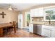 Kitchen with stainless steel appliances, granite countertops, white cabinets and a ceiling fan at 4409 Woodward Mill Rd, Sugar Hill, GA 30518