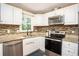 Modern kitchen featuring stainless steel appliances, tile backsplash, granite countertop and white cabinetry at 4409 Woodward Mill Rd, Sugar Hill, GA 30518