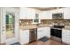 Modern kitchen with stainless steel appliances, white cabinets, and granite countertops at 4409 Woodward Mill Rd, Sugar Hill, GA 30518