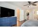 Bedroom showcasing wood floors, a large TV, dresser, and access to walk-in closet and en suite bath at 4409 Woodward Mill Rd, Sugar Hill, GA 30518