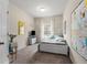 Well-lit bedroom with a white bed frame, desk, and window with neighborhood views at 197 Cherokee Reserve Cir, Canton, GA 30115