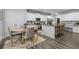 Bright kitchen and dining area with white cabinetry, stainless steel appliances, and wood-look floors at 197 Cherokee Reserve Cir, Canton, GA 30115