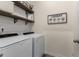 Well-organized laundry room featuring a washer, dryer, and decorative shelving at 197 Cherokee Reserve Cir, Canton, GA 30115