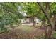Backyard view featuring a covered wooden pergola, grill, table and seating in a yard with mature landscaping at 2545 Gatewater Ct, Cumming, GA 30040