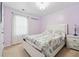 Bedroom showcasing lilac walls, carpeted floors, and a white bed frame with patterned duvet at 2545 Gatewater Ct, Cumming, GA 30040