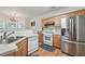 Well-lit kitchen featuring stainless steel refrigerator, white appliances, and light wood cabinets at 2545 Gatewater Ct, Cumming, GA 30040