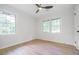 Bright bedroom featuring new wood flooring, two large windows, a ceiling fan and neutral paint at 2975 Rollingwood Se Ln, Atlanta, GA 30316