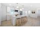 Modern white kitchen with stainless steel appliances, an island with bar seating, and stylish pendant lighting at 2975 Rollingwood Se Ln, Atlanta, GA 30316