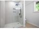 Walk-in shower featuring gray and white tiles with a sleek shower head at 2975 Rollingwood Se Ln, Atlanta, GA 30316