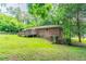 Secluded backyard with a brick house featuring a deck, surrounded by lush greenery at 4567 Parkway Cir, Atlanta, GA 30349