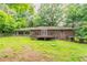 Large backyard featuring a deck, a covered patio, and mature trees that offer plenty of shade at 4567 Parkway Cir, Atlanta, GA 30349
