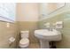 A clean, well-maintained bathroom with a pedestal sink, toilet, and tiled walls at 4567 Parkway Cir, Atlanta, GA 30349