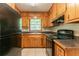 Functional kitchen featuring classic cabinetry, black appliances, and tiled flooring at 4567 Parkway Cir, Atlanta, GA 30349