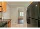 Additional view of kitchen leading to a room with hardwood floors and a black refrigerator at 4567 Parkway Cir, Atlanta, GA 30349