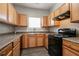 This kitchen features light wood cabinetry, dark countertops and modern black appliances at 4567 Parkway Cir, Atlanta, GA 30349