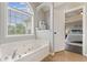 Bright bathroom with jacuzzi tub and large window, conveniently located near main bedroom at 113 Westchester Xing, Canton, GA 30115