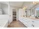 Bright bathroom featuring double sinks, a jacuzzi tub, and an arched window at 113 Westchester Xing, Canton, GA 30115