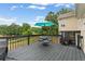 An outdoor deck with a table and chairs, umbrella and view to the lush backyard at 113 Westchester Xing, Canton, GA 30115