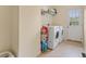 Laundry room with a white washer and dryer, shelving, and a view to the backyard at 113 Westchester Xing, Canton, GA 30115