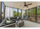 Screened porch furnished with sectional sofa and chair overlooking wooded backyard at 113 Westchester Xing, Canton, GA 30115