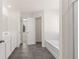 Bright bathroom features dual vanity, separate tub and shower, and gray wood-look tile flooring at 1149 Blue Juniper Cir, Loganville, GA 30052