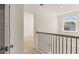 Hallway with neutral carpeting and wood and black iron railing at 1149 Blue Juniper Cir, Loganville, GA 30052