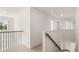Hallway with new neutral carpeting and staircase with wood and black iron railing at 1149 Blue Juniper Cir, Loganville, GA 30052