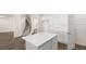 Kitchen area features an island, white cabinets, stainless appliances, and an open view to the staircase at 1149 Blue Juniper Cir, Loganville, GA 30052