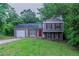 Charming two-story home featuring red shutters, a red door, green grass, and mature trees in a suburban setting at 4634 Garden Hills Dr, Stone Mountain, GA 30083