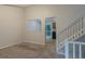 Open living room featuring an opening to a kitchen, neutral walls, and a staircase leading to upper floor at 4634 Garden Hills Dr, Stone Mountain, GA 30083