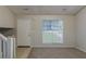 Bright living room featuring a large window, neutral paint, modern carpet, and a white entry door at 4634 Garden Hills Dr, Stone Mountain, GA 30083