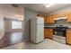 Well-lit kitchen with wooden cabinets and essential appliances; view into the living area at 7070 Ravenwood Ln, Lithonia, GA 30038