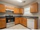Neutral kitchen featuring ample wood cabinets, white appliances, and tile floor at 7070 Ravenwood Ln, Lithonia, GA 30038