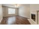 Bright living room features a fireplace, ceiling fan, and beautiful dark wood floors at 7070 Ravenwood Ln, Lithonia, GA 30038