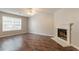 Bright living room with wood floors, a large window, and a cozy fireplace at 7070 Ravenwood Ln, Lithonia, GA 30038