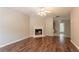 Inviting living room with wood flooring, fireplace, and a view into the adjacent kitchen at 7070 Ravenwood Ln, Lithonia, GA 30038