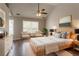 A staged primary bedroom featuring a ceiling fan and two windows at 7070 Ravenwood Ln, Lithonia, GA 30038