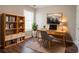 Home office with desk, rug, shelving, and natural light at 7070 Ravenwood Ln, Lithonia, GA 30038