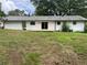 Home's backyard with large trees, patio, grassy field, and white brick at 1066 Cleavemark Dr, Clarkston, GA 30021