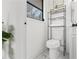 Clean and simple bathroom with a marble floor, white toilet, and shelves at 1066 Cleavemark Dr, Clarkston, GA 30021