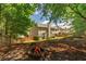 Secluded backyard with a fire pit, surrounded by mature trees and greenery at 939 Bendleton Dr, Woodstock, GA 30188