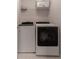 Well-lit laundry room with modern appliances, overhead shelving and tile flooring at 939 Bendleton Dr, Woodstock, GA 30188
