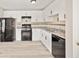 Kitchen with white cabinets, black appliances, and modern flooring at 946 Redan Trce, Stone Mountain, GA 30088