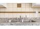 Stainless steel double sink with tiled backsplash and granite countertops at 946 Redan Trce, Stone Mountain, GA 30088